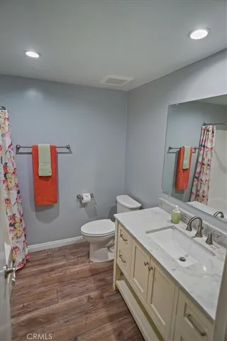 a spacious bathroom with a granite countertop sink and a toilet