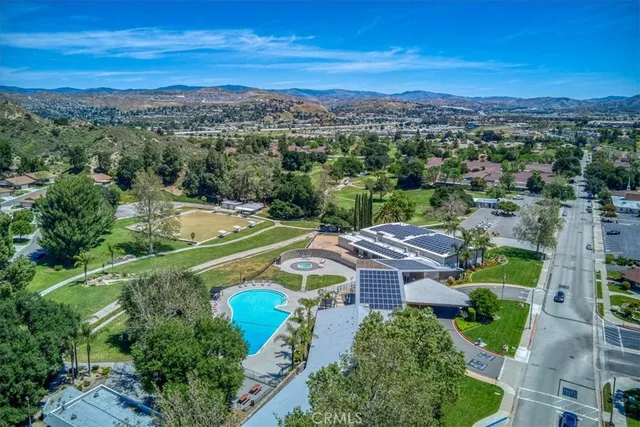 an aerial view of residential houses with outdoor space and trees
