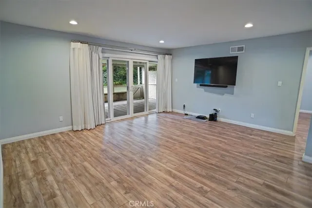 a view of a livingroom with wooden floor and a flat screen tv