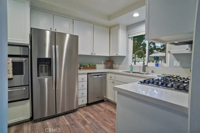 a kitchen with stainless steel appliances granite countertop a refrigerator sink and stove