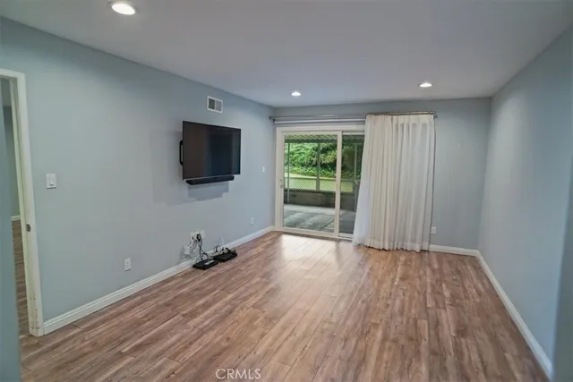 a view of a livingroom with wooden floor and a flat screen tv