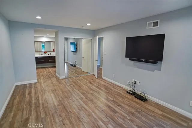 a view of a livingroom with wooden floor and a flat screen tv