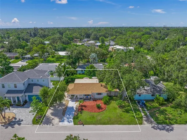 an aerial view of a house with a yard and lake view