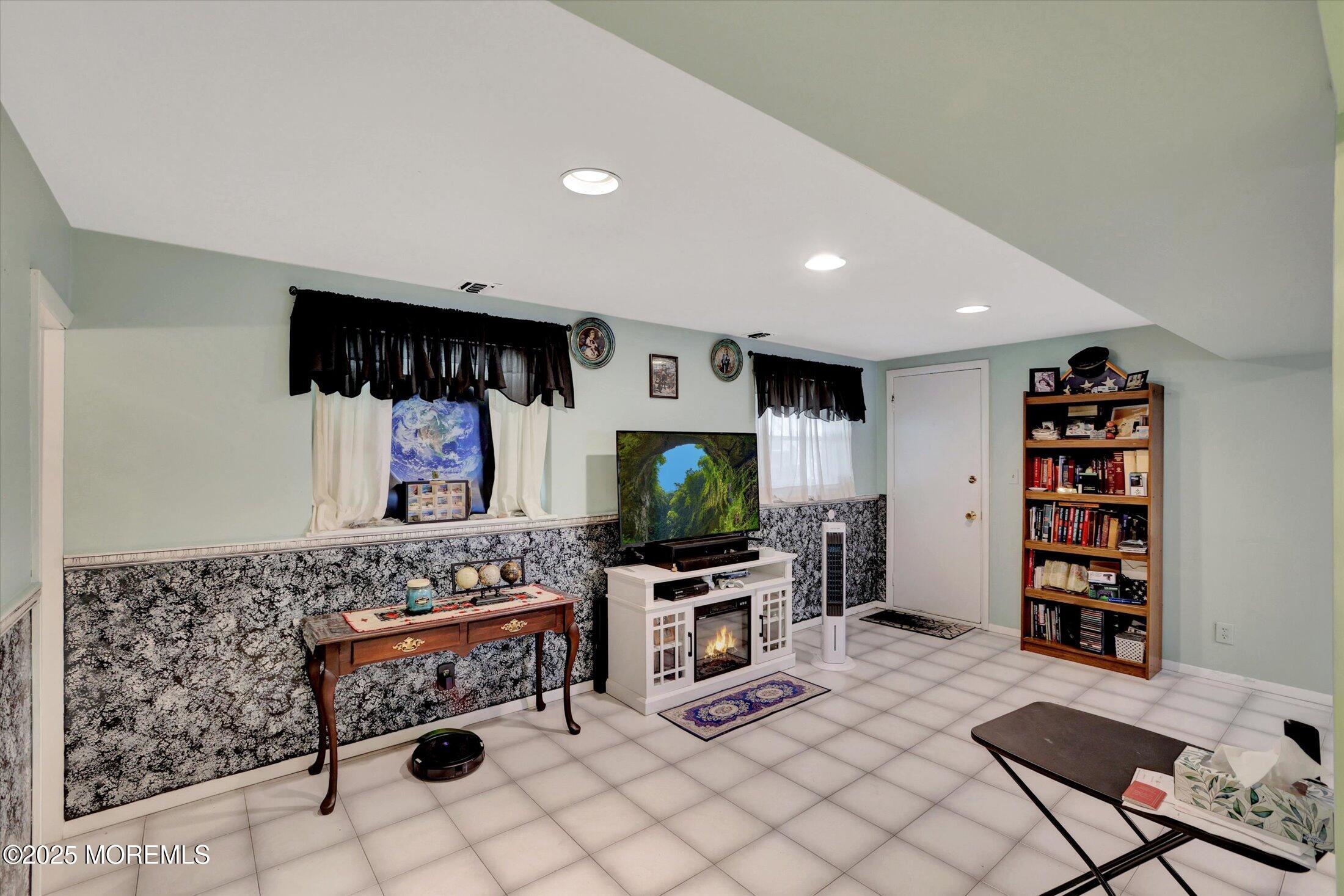 12 Steven Place Jackson, NJ 08527 - Photo 14 of 31 a living room with furniture a flat screen tv and a fireplace