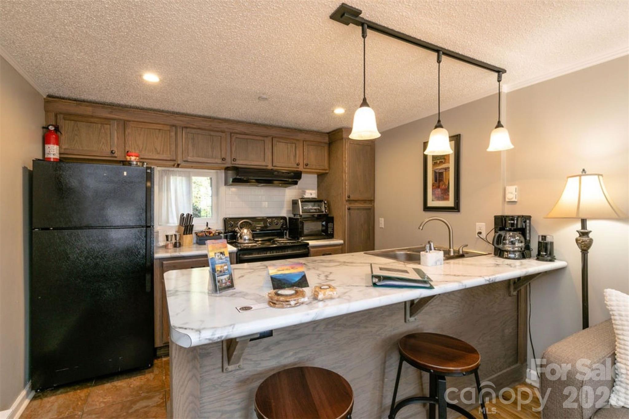 7 North Delano Road Asheville, NC 28805 - Photo 15 of 32 a kitchen with refrigerator a sink and chairs