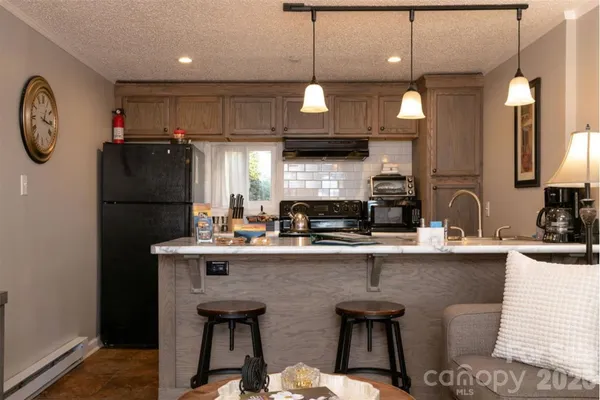 a kitchen with stainless steel appliances granite countertop a sink a stove and a refrigerator