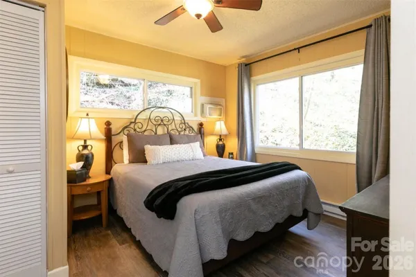 a bedroom with a bed and a large window with outer view