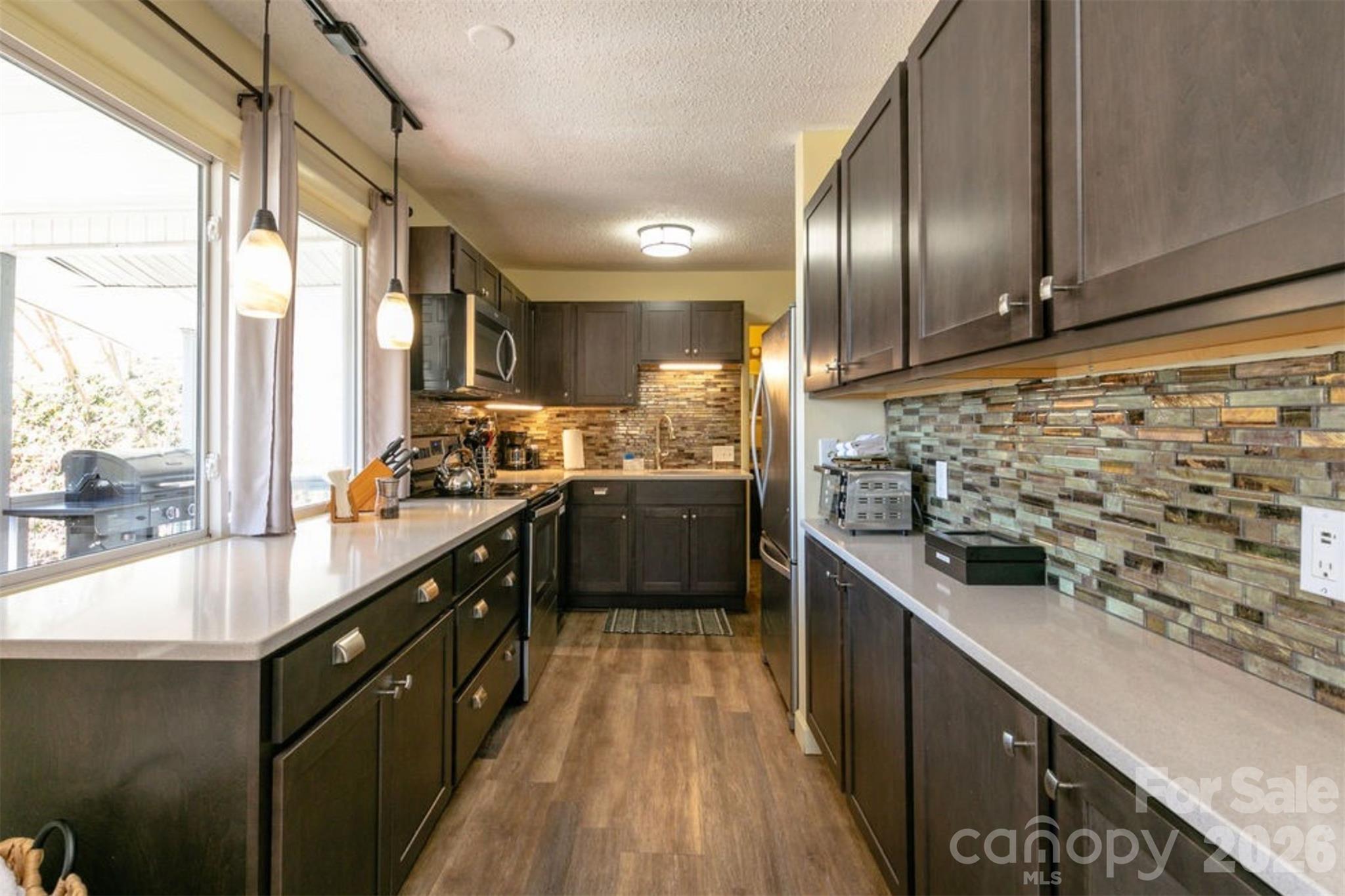 7 North Delano Road Asheville, NC 28805 - Photo 27 of 32 a kitchen with stainless steel appliances a sink a counter top space a large window and stainless steel appliances