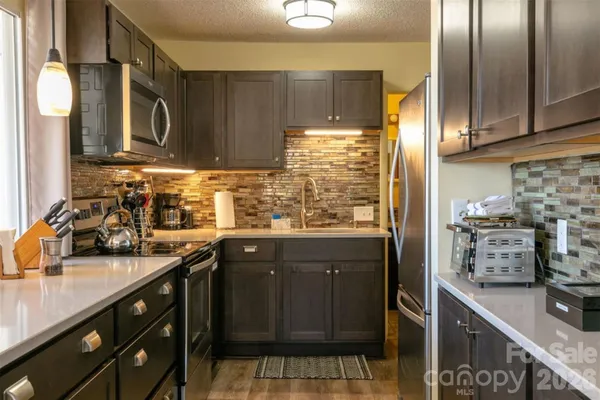 a kitchen with stainless steel appliances a sink stove and cabinets