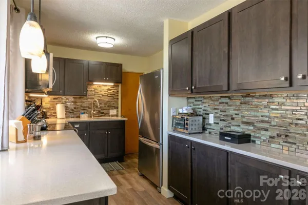 a kitchen with stainless steel appliances granite countertop a sink a stove and a refrigerator