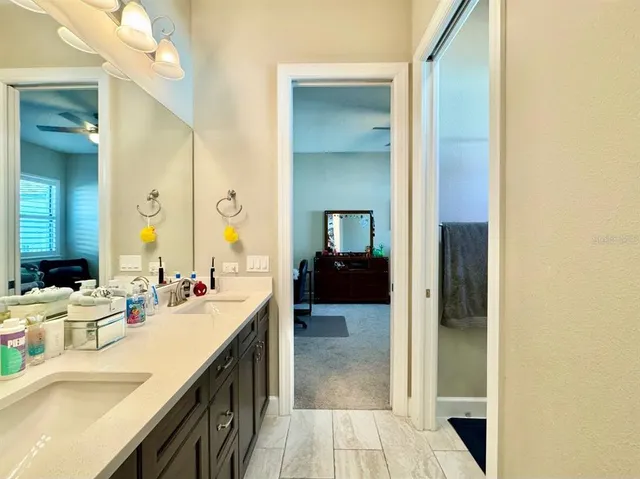 a large bathroom with a double vanity sink a large mirror and a shower