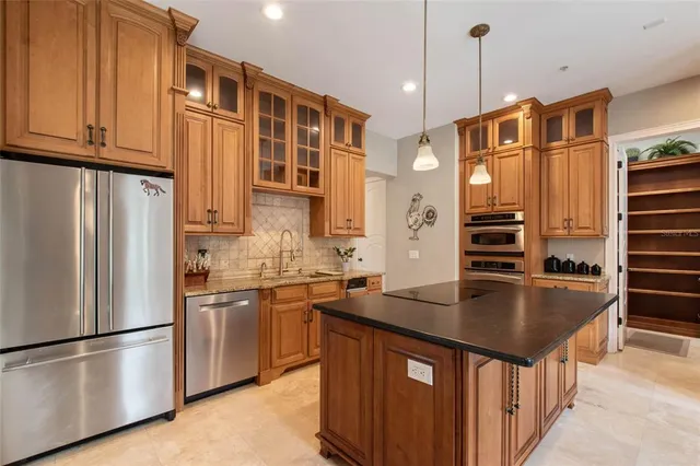 a kitchen with stainless steel appliances granite countertop a sink a stove and refrigerator