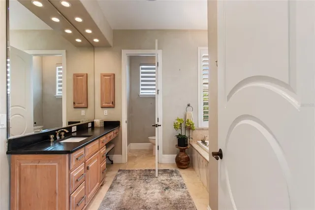 a spacious bathroom with a granite countertop sink and a mirror
