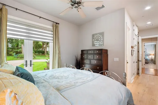 a bedroom with a bed dresser and a large window