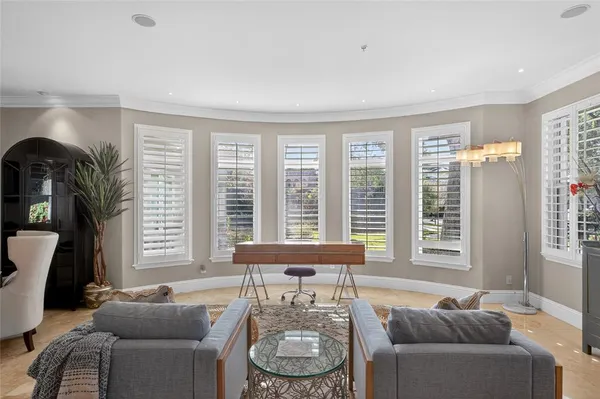 a bedroom with a bed a chair and a large window