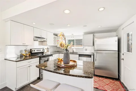 a kitchen with a refrigerator a stove a sink dishwasher and white cabinets with wooden floor