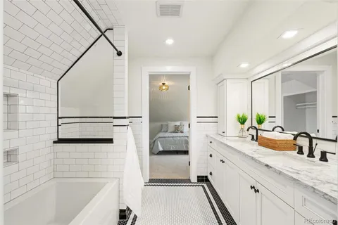 a bathroom with a tub sink and mirror