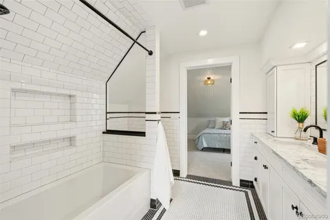 a bathroom with a bathtub sink and mirror