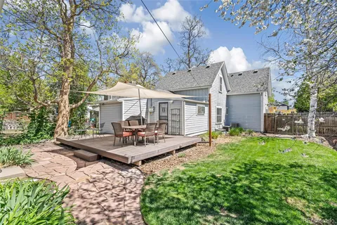 a view of a house with backyard and sitting area