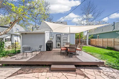 a view of a patio with table and chairs with wooden floor and fence