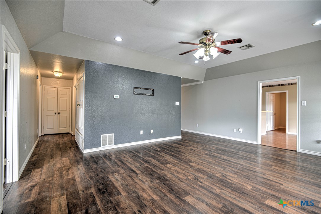 809 Hudson Lane Eddy, TX 76524 - Photo 11 of 48 a view of an empty room with wooden floor and a ceiling fan