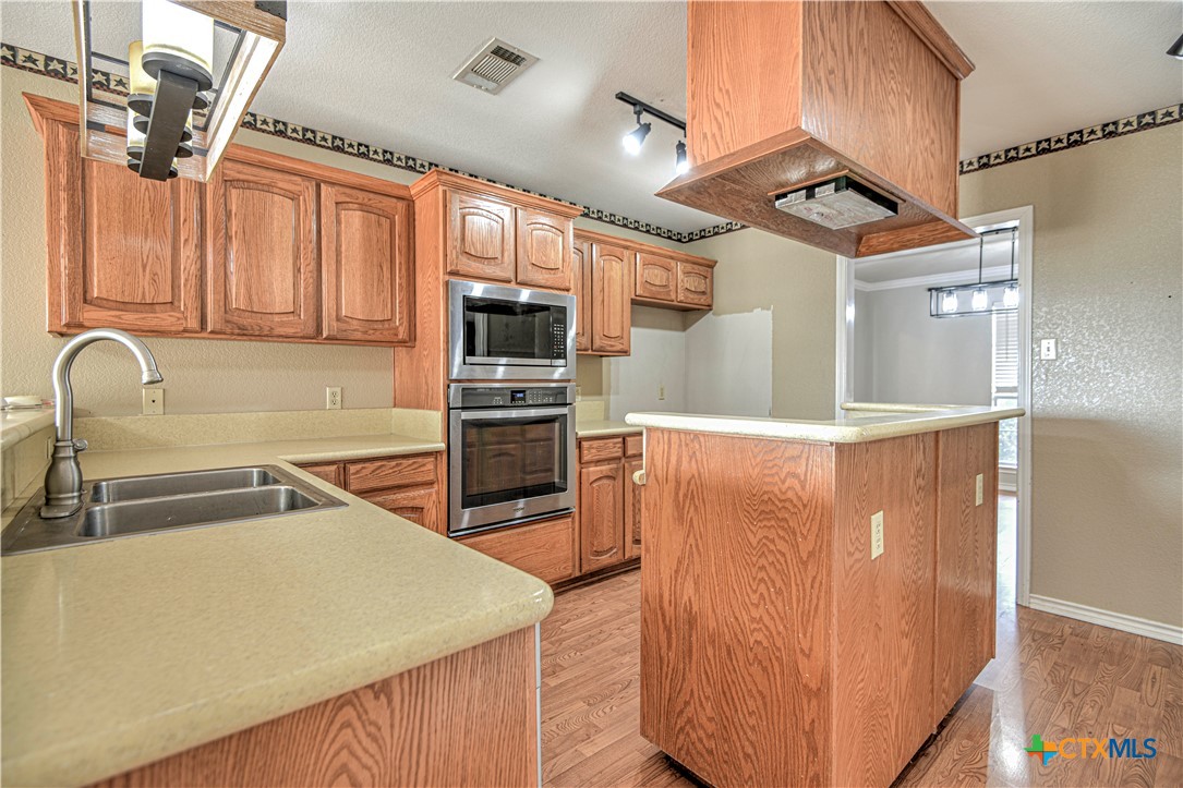 809 Hudson Lane Eddy, TX 76524 - Photo 12 of 48 a kitchen with stainless steel appliances granite countertop a refrigerator a sink and wooden cabinets