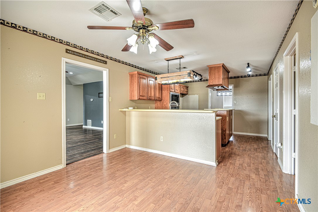 809 Hudson Lane Eddy, TX 76524 - Photo 13 of 48 a view of a kitchen with wooden floor and a ceiling fan