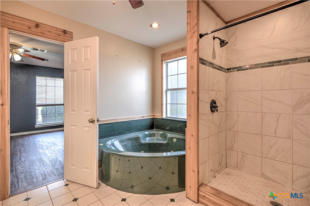 809 Hudson Lane Eddy, TX 76524 - Photo 23 of 48 a bathroom with a granite countertop sink a mirror and shower