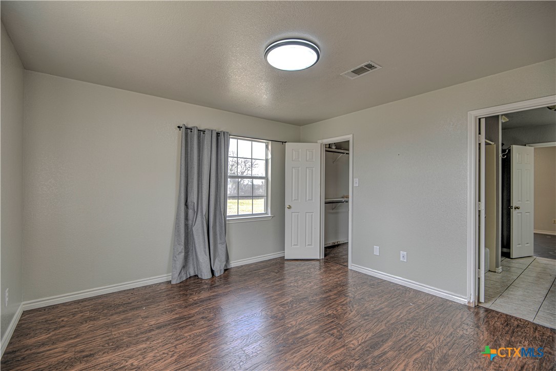 809 Hudson Lane Eddy, TX 76524 - Photo 27 of 48 an empty room with wooden floor and windows