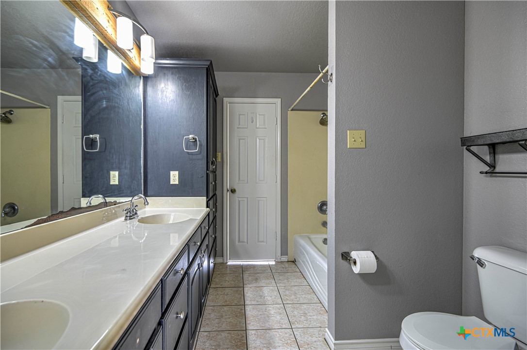 809 Hudson Lane Eddy, TX 76524 - Photo 30 of 48 a spacious bathroom with a granite countertop sink a toilet and shower