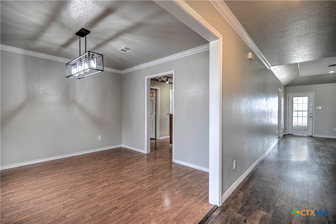809 Hudson Lane Eddy, TX 76524 - Photo 6 of 48 a view of a hallway with wooden floor and chandelier