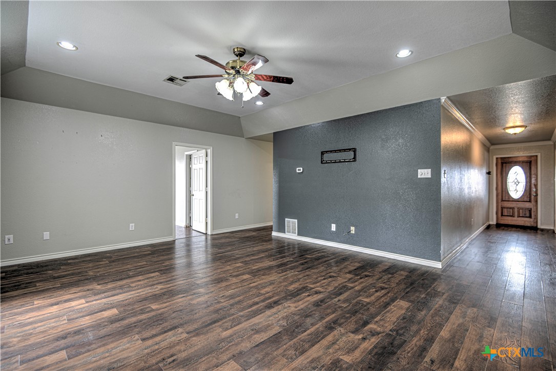 809 Hudson Lane Eddy, TX 76524 - Photo 9 of 48 a view of an empty room with wooden floor and a chandelier