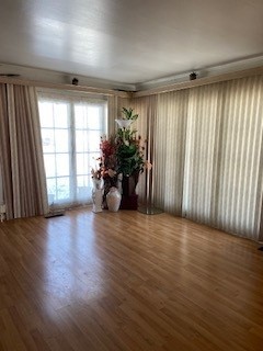 3029 West 83rd Place Chicago, IL 60652 - Photo 2 of 10 an empty room with wooden floor and windows with curtains