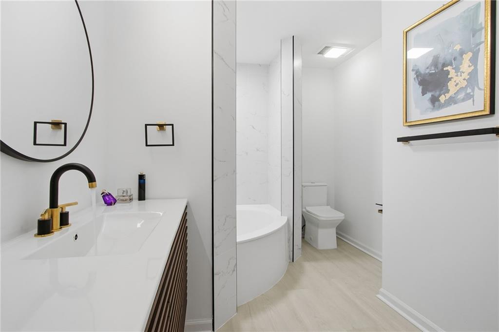 970 Sidney Marcus Boulevard Northeast, Unit 2203 Atlanta, GA 30324 - Photo 16 of 39 a bathroom with a sink a toilet and a shower