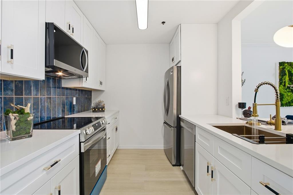 970 Sidney Marcus Boulevard Northeast, Unit 2203 Atlanta, GA 30324 - Photo 4 of 39 a kitchen with stainless steel appliances granite countertop a sink a stove and a refrigerator