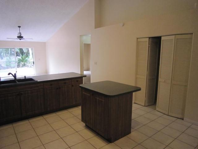 7408 Shell Ridge Terrace Lake Worth, FL 33467 - Photo 11 of 23 a kitchen with a sink a window and a wooden cabinets