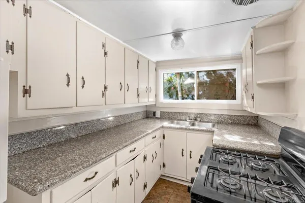 a kitchen with a sink stove top oven and cabinets