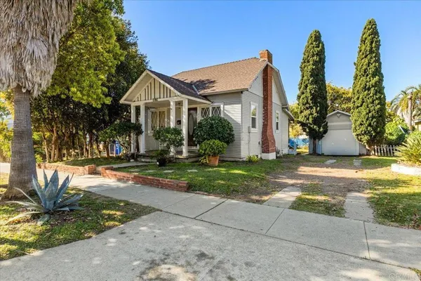 a view of a house with backyard and a tree