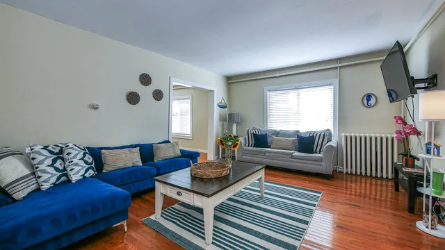 a living room with furniture wooden floor and a flat screen tv