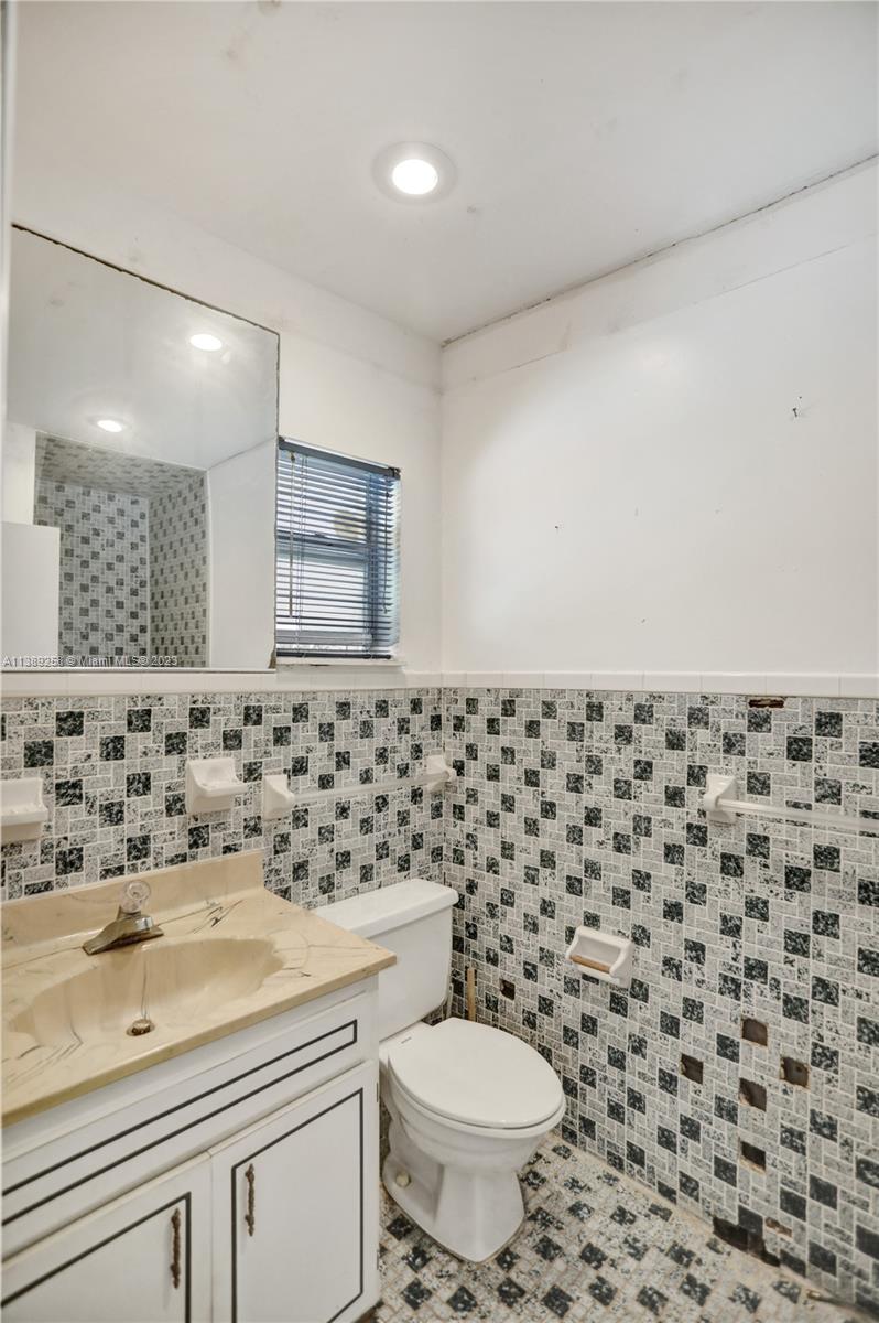837 Washington Street Hollywood, FL 33019 - Photo 17 of 65 a bathroom with a sink a toilet and a mirror