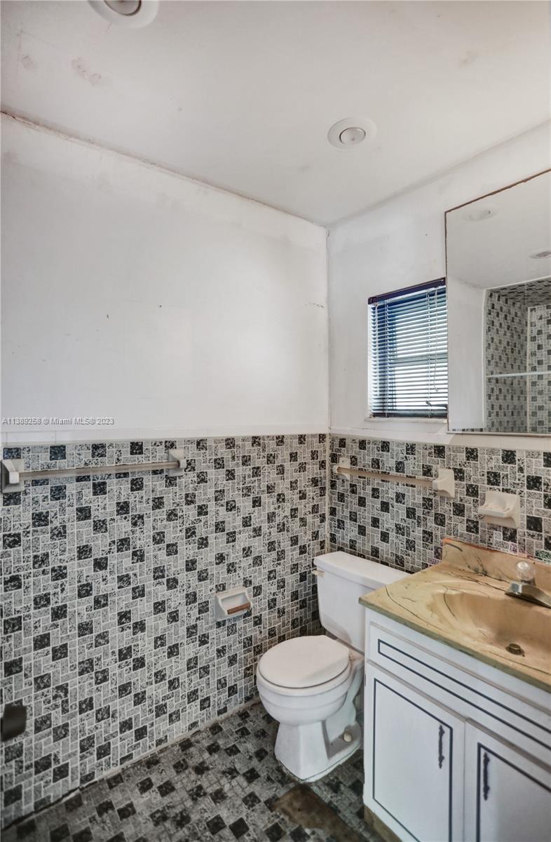 837 Washington Street Hollywood, FL 33019 - Photo 19 of 65 a bathroom with a toilet a sink and a mirror