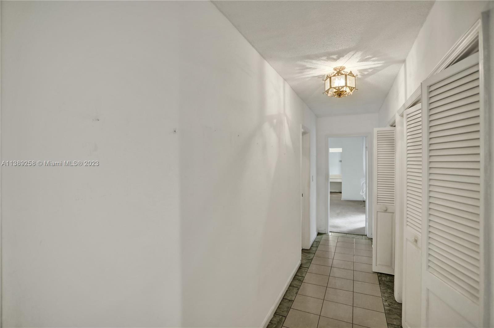 837 Washington Street Hollywood, FL 33019 - Photo 52 of 65 a view of a hallway with a chandelier and a dining room