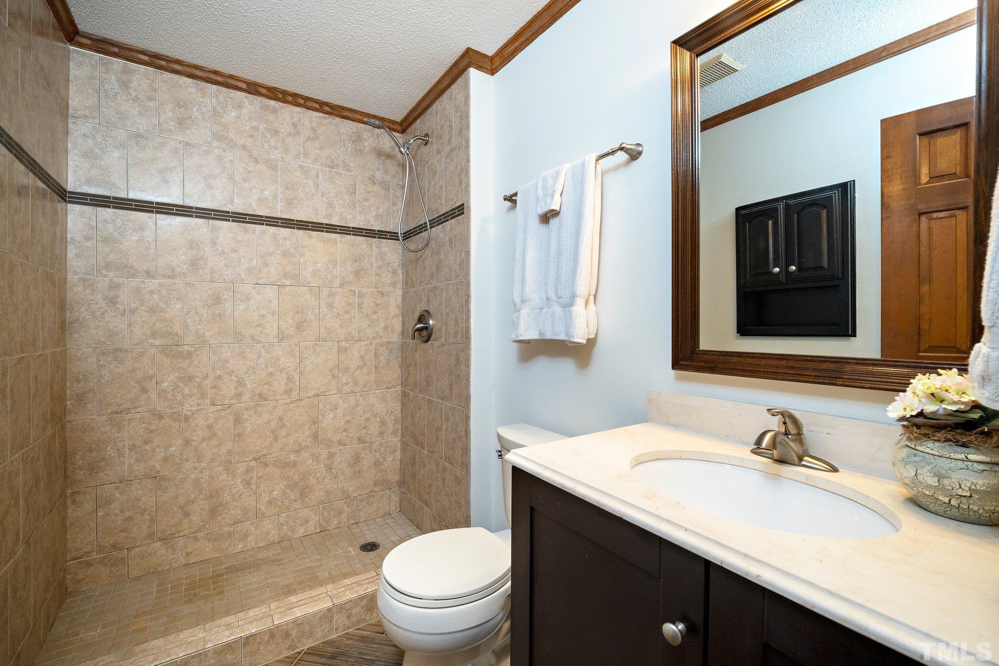 902 Bridge Way Raleigh, NC 27615 - Photo 16 of 27 a bathroom with a granite countertop sink toilet and shower