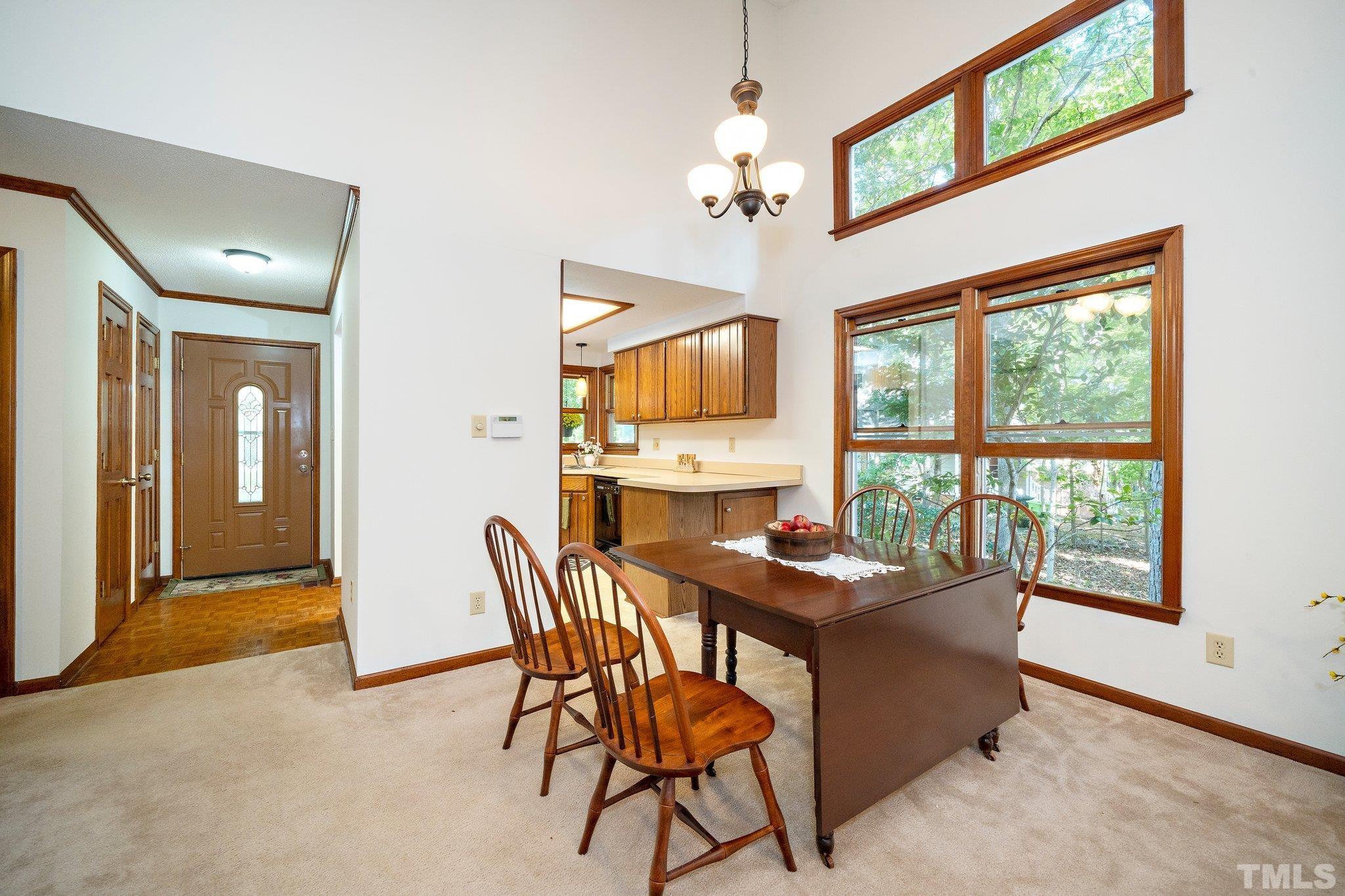 902 Bridge Way Raleigh, NC 27615 - Photo 19 of 27 a dining room with furniture a livingroom and chandelier