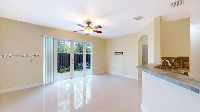 an empty room with ceiling fan and window