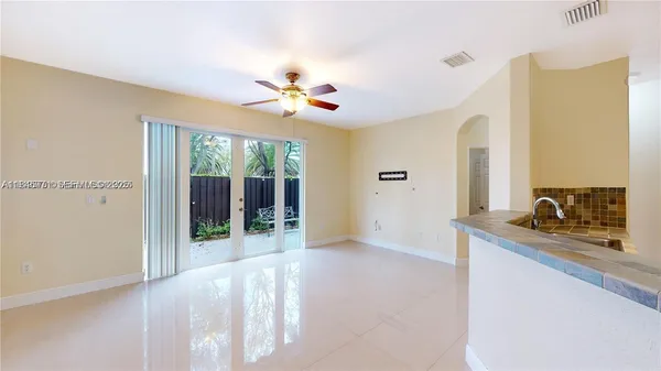 an empty room with ceiling fan and window
