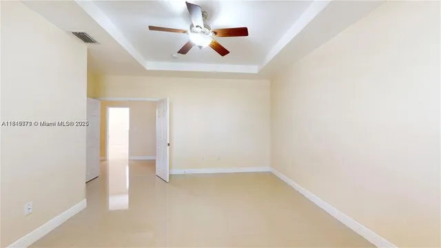 an empty room with a window and a fan