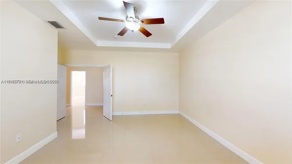 an empty room with a window and a fan