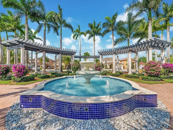 front view of multi story residential apartment building with a yard and palm trees