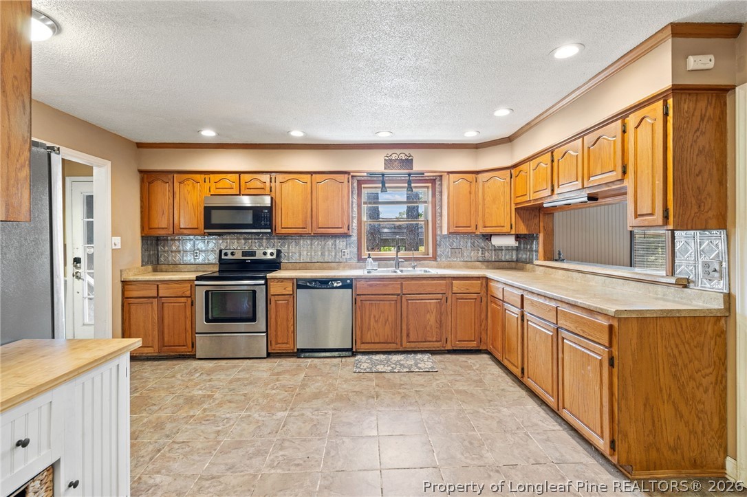 5605 MacGregor Court Fayetteville, NC 28304 - Photo 13 of 49 a kitchen with stainless steel appliances granite countertop a stove refrigerator and cabinets